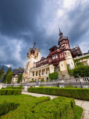 Peles Castle panoramic view. Wide view of Peles Castle surrounded by gardens and mountain landscape