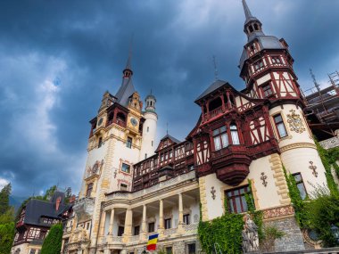 Peles Kalesi mimari detayları. Dramatik gökyüzünün altındaki Peles Kalesi kuleleri ve balkonlarının detaylı görüntüsü