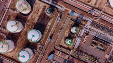 Petrol deposu için ince tankların üzerinde daireler çiziyor. Kimya fabrikasındaki siloları birbirine bağlayan birden fazla boru var..