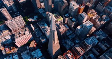 San Francisco, California, ABD merkezindeki Transamerica Piramidinin tepesine daha yakın uçuyor. Şehir merkezindeki yüksek binaların çatılarına bak..