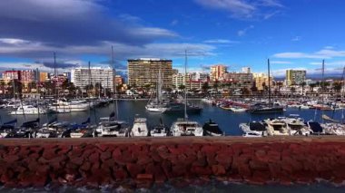 Yat kulübünü deniz dalgalarından koruyan taş baraj. Rıhtımlarda çok sayıda gemi var..