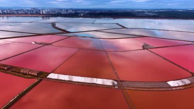 Yüksek açılı pembe tuz tepsileri ve tuz yığınları. Beyaz tuz yığınları ve endüstriyel makinelerle pembe tuz rezervlerinin geometrik deseni.