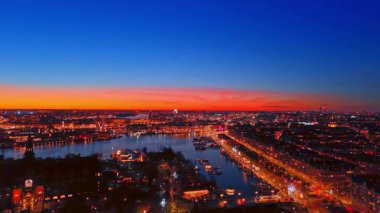 Stockholm rıhtımının ufuk çizgisi gün batımında. Şehir silueti, su ve parlak turuncu günbatımı ufkunun geniş hava görüntüsü..