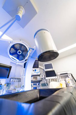 Cerrahi C-kolu ve ışıkların düşük açılı görüntüsü. Modern bir ameliyathanede profesyonel tıbbi görüntüleme ve aydınlatma donanımı..