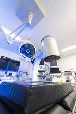 Steril ameliyathanede gelişmiş floroskopi sistemi. Modern bir hastane cerrahi bölümünde profesyonel görüntüleme ekipmanları ve monitörler.