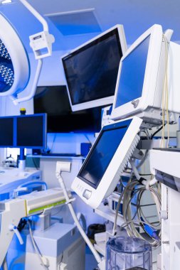 Modern ameliyathanelerdeki tıbbi izleme ekranlarına yakından bakın. Nöroşirürji odasındaki çoklu tanı monitörlerine ve elektronik ekipmanlara odaklanın..