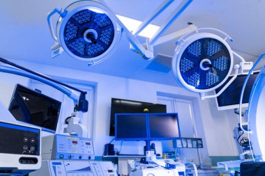 Nöroşirürji ameliyathanesine lambalar ve monitörlerle genel bakış. Çift lambalı ve tanı ekipmanlı profesyonel cerrahi süitinin geniş açı perspektifi.