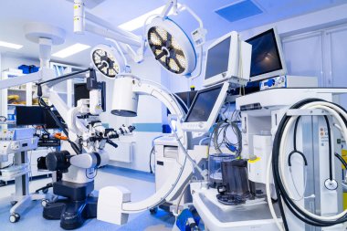 Ameliyat odasında özel tıbbi monitörler ve C-kol sistemi var. Modern bir nöroşirurji ameliyathanesinde tıbbi gösterileri ve C-kolu floroskopi ekipmanlarını kapatın..