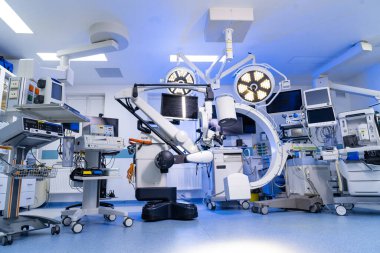 Gelişmiş tıbbi ekipmanlarla modern beyin cerrahisi ameliyathanesi. Mikroskop ve C-kolu x-ray makinesi ile steril cerrahi tiyatronun geniş açı görüntüsü.
