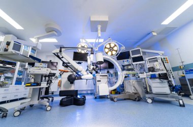 Çoklu ekranlı yüksek teknoloji nöroşirürji ameliyathanesi. Mikroskop, C-kol ve dijital çalışma istasyonlarını gösteren geniş bir beyin cerrahisi odası..