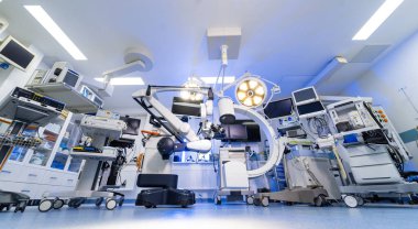 Dijital ekipmanlı boş nöroşirurji tiyatrosunun panoramik görüntüsü. Cerrahi lambalar ve görüntüleme sistemlerinin yer aldığı tam donanımlı bir sinir cerrahisi odası geniş açı..