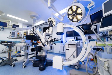 C-kolu ve cerrahi mikroskop ile tam bir sinir cerrahisi kurulumu. Steril bir odada gelişmiş robotik cerrahi ekipman ve görüntüleme araçları geniş açı.