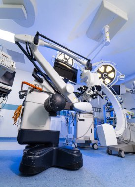 Modern cerrahi süitinde yüksek teknolojili nörocerrahi mikroskop sistemi. Mavi tonlu ameliyathanede robotik cerrahi mikroskop ve ameliyat lambalarının detaylı görüntüsü..
