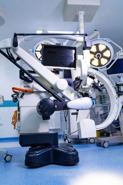 Ameliyathanede robotik cerrahi mikroskobun yan görüntüsü. Hastane ortamındaki tekerlekli mobil nörocerrahi mikroskobun profil görüntüsü.