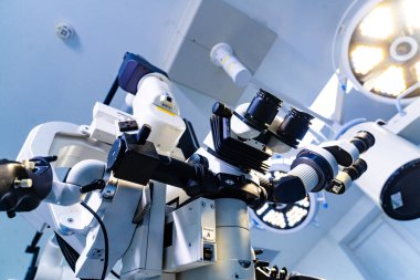 Nöroşirürji ameliyathanesinde profesyonel cerrahi mikroskop. Tavanda cerrahi lambalar olan tıbbi mikroskobun düşük açılı görüntüsü.