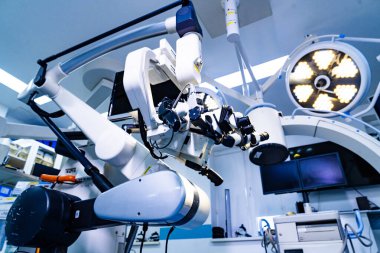 Sinema salonunda eklemli kol üzerinde nörocerrahi mikroskop sistemi. Monitörler ve cerrahi lambalarla geniş açılı robotik mikroskop kolu.