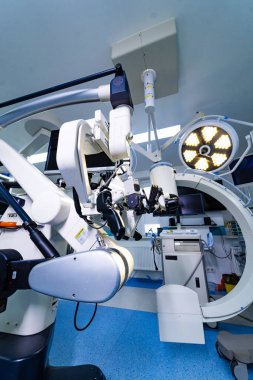 Modern tıp tiyatrosunda cerrahi mikroskoba açılı bakış açısı. Eklem kolu ve monitörleri gösteren özel bir nörocerrahi mikroskobun yan perspektifi.