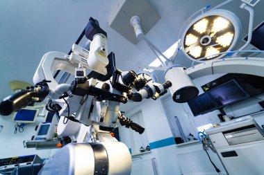 Modern nöroşirürji odasındaki cerrahi mikroskobu kapatın. Parlak bir tıbbi iç mekandaki kontrol kollarıyla optik cerrahi mikroskobun ayrıntılı görüntüsü.