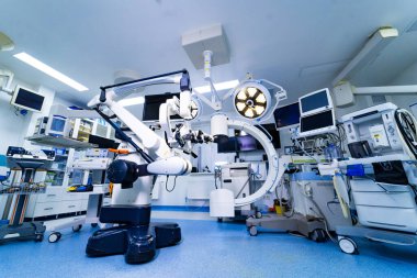 Mikroskop ve görüntüleme teçhizatıyla nöroşirürji ameliyathanesinin tam görüntüsü. Mikroskop, C-kol ve anestezi izleme rafları da dahil olmak üzere geniş bir nörocerrahi düzeneği..