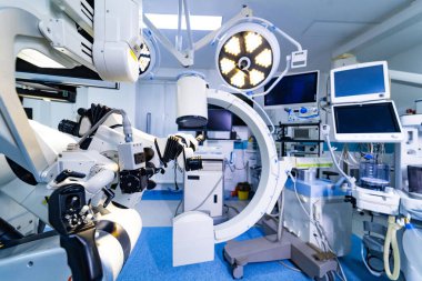 Nörocerrahi tiyatrosunda robot cerrahi mikroskobun yan profili. Ayarlanabilir kolları ve optik kafası olan büyük bir cerrahi mikroskop sisteminin detaylı yan görüntüsü.