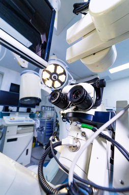 Steril hastane ameliyathanesinde profesyonel cerrahi mikroskop sistemi. Monitörler ve tıbbi ekipmanlarla yüksek teknolojili nöroşirürji mikroskobuna bakış açısı.