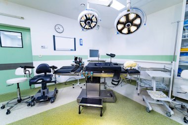 Ameliyat masası ve ekipmanlar beyin cerrahisi ameliyathanesinde. LED lambaların altında ayarlanabilir bir nöroşirürji masasının merkezli görüntüsü.