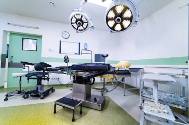 Steril ekipman ve masayla profesyonel beyin cerrahisi. Masası, ışıkları ve saati olan tam bir nöroşirürji süitinin perspektif görüntüsü.