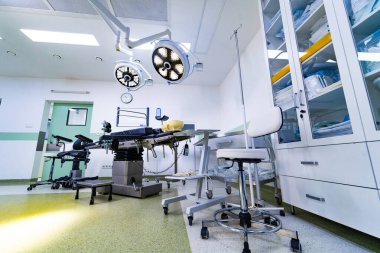 Depo dolapları olan bir ameliyathane. Cerrahi tiyatro perspektifi tıbbi malzeme dolaplarını, ameliyat masasını ve gelişmiş ışıklandırma sistemini gösteriyor..