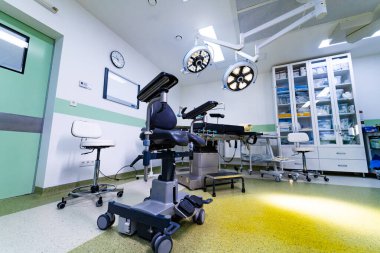 Tıbbi aletleri ve dolapları olan yüksek teknoloji cerrahi odası. LED lambaları, ameliyat masası ve depolama mobilyaları olan modern ameliyathane..