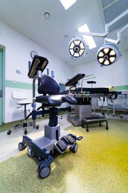 Cerrahi tiyatroda ayarlanabilir masalı tıbbi ekipmanlar. Ameliyat odasının içi cerrahi masa, ayak pedalları ve yukarıdaki lambalar üzerine odaklanmış..