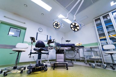 Cerrahi tiyatronun geniş görüş açısı ve çift tepeli lambaları var. Merkezi cerrahi masası ve tıbbi malzeme dolapları olan geniş bir ameliyathane..