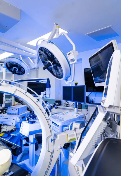 C-kolu ve monitörleri olan yüksek teknoloji beyin cerrahisi odası. Floroskopi C-kolu, yukarıdaki ışıklar ve izleme istasyonu da dahil olmak üzere cerrahi süitin geniş görüşü..