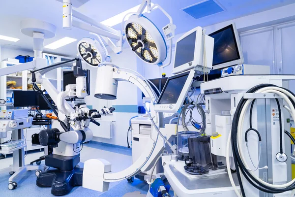 Ameliyat odasında özel tıbbi monitörler ve C-kol sistemi var. Modern bir nöroşirurji ameliyathanesinde tıbbi gösterileri ve C-kolu floroskopi ekipmanlarını kapatın..