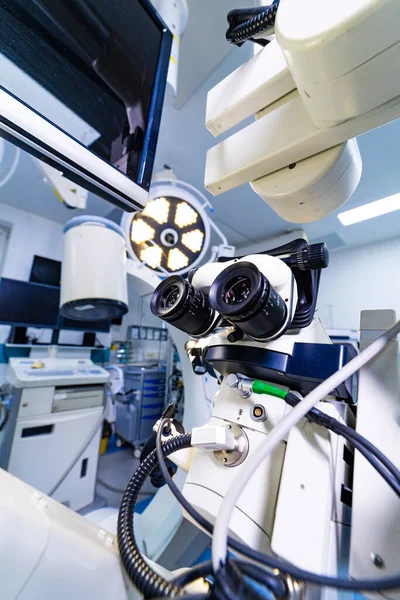 Steril hastane ameliyathanesinde profesyonel cerrahi mikroskop sistemi. Monitörler ve tıbbi ekipmanlarla yüksek teknolojili nöroşirürji mikroskobuna bakış açısı.
