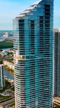 Atlantik Okyanusu kıyısında sıra sıra inşa edilmiş yüksek binalara yaklaşıyoruz. İHA 'dan Miami Sahili' nin mimarisi. Dikey video