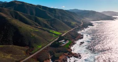 Big Sur kayalıklarındaki sahil yolu ve bina kompleksi. 1. Otoyol ile Pasifik 'in çarpan dalgaları arasına kurulmuş küçük bir tesisin kuş bakışı görüntüsü..