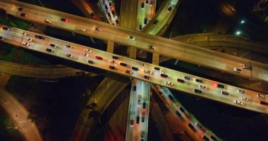 Çok sayıda hareket eden arabayla çok katlı bir kavşak. Modern Los Angeles, California, ABD 'de gece yolculuk. Üst görünüm.