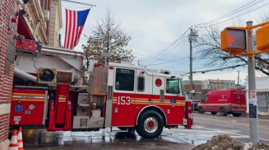 New York, ABD, 9 Şubat 2026: Amerikan bayrağı altında kırmızı itfaiye aracı duruyor. New York İtfaiyesi Kış günü.