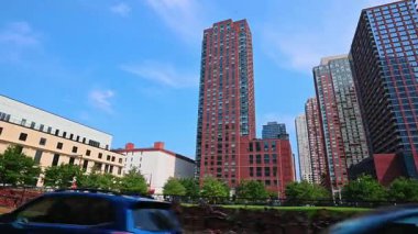 New York, ABD, 5 Ağustos 2025: Park halindeki otomobiller ve tuğla yığınlarıyla dolu inşaat alanı boyunca araba yolculuğu. New York, ABD 'deki tuğla döşemeli yüksek binanın alçak açılı görüntüsü..