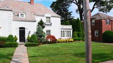 New York, ABD, 5 Ağustos 2025: Yeşil mahalledeki güzel evler. Bereketli yeşilliklerle konut alanı boyunca sürüş.