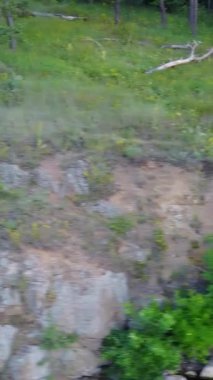 Kayadaki Sillouette Adam. Nehrin yanındaki kayalıklarda gün batımlı silüet adam.