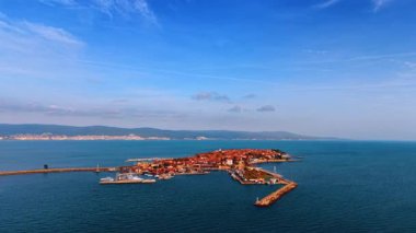 Denizde bir yarımada kasabasının uzak hava manzarası. Mavi deniz suyuyla çevrili eski bir kasabanın geniş açılı görüntüsü..