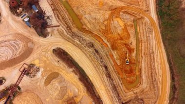 Makinelerle birlikte yüksek açılı kum ocağı düzeni. Taşıyıcılar, kazıcılar ve su kanallarının yer aldığı kum çıkarma alanının hava perspektifi.