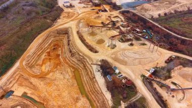 Kum işleme alanı ve çukur. Yüksek açı, çıkarma çukurunu, taşıyıcı sistemleri ve işlenmiş kum tepeciklerini gösteriyor..