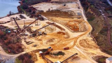 Taşıma bantları ve işleme tesisi olan endüstriyel kum ocağı. Taşıyıcı sistemleri, stokları, kamyonları ve yakındaki gölü olan yüksek açılı kum çıkarma alanı.