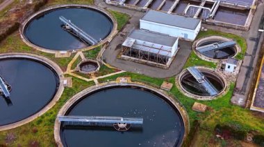 İkincil açıklayıcıların ve teknik binaların havadan görüntüsü. Modern bir arıtma tesisinde dairesel tortu tankları ve pompalama istasyonlarının ayrıntıları.
