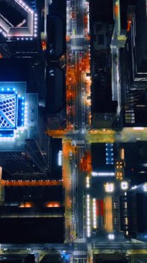 Geceleri Philadelphia şehir merkezindeki gökdelenlerin üzerinde uçuyor. Tepeden parlak canlı şehir manzarası. Dikey video