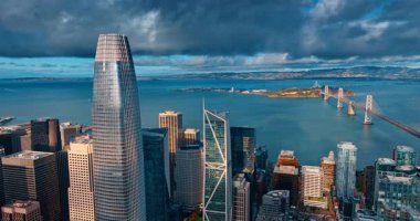 San Francisco, ABD, 9 Ocak 2026: Fırtına bulutları altında Satış Gücü Kulesi ve Bay Köprüsü 'nün geniş görüş alanı. San Francisco şehir merkezi, Define Adası ve körfezin panoramik manzarası.