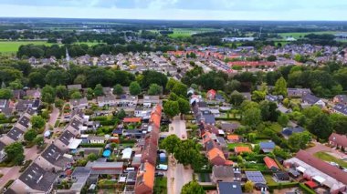 Hollanda mahallesi. Yarı müstakil evler, kırmızı kiremitli çatılar ve yeşil bahçelerle dolu bir banliyö caddesinin havadan bakış açısı.