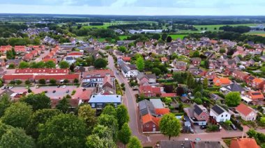 Köy kavşağı ve konut binalarının hava perspektifi. Temiz bir asfalt yolu, bir kavşak ve Hollanda kasabasındaki çeşitli tuğlalı konutların manzarası.